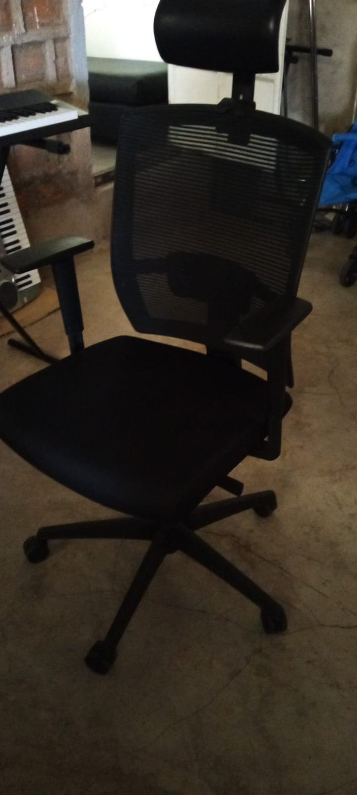Black ergonomic office chair featuring a mesh backrest, headrest, and armrests on wheels.